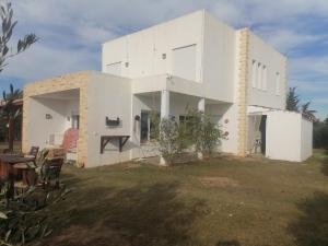 una grande casa bianca con cortile di Villa de luxe avec piscine a Korba