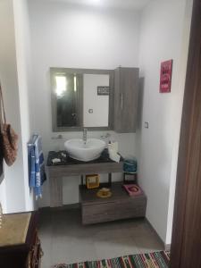 W łazience znajduje się umywalka i lustro. w obiekcie Villa de luxe avec piscine w mieście Korba