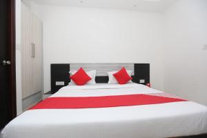 ニューデリーにあるOYO Hotel Privaのベッドルーム(赤い枕の大きな白いベッド付)