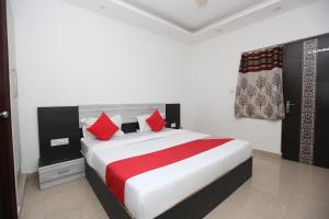 ein Schlafzimmer mit einem großen Bett mit roten Kissen in der Unterkunft OYO Hotel Priva in Neu-Delhi