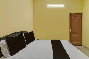 een slaapkamer met een zwart-wit bed en een deur bij OYO Grand Stay in Chennai