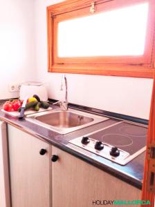 Una encimera de cocina con un fregadero y una ventana. en Aucanada Love Nest, en Alcudia
