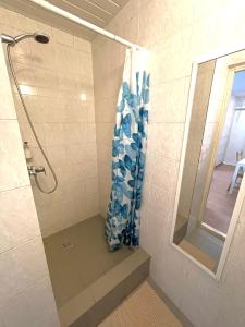 a shower with a blue shower curtain in a bathroom at Savan House "Easy Kaunas" in Kaunas