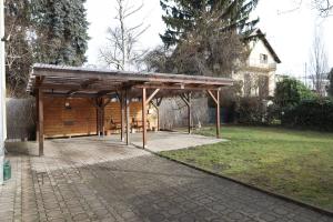 a wooden pavilion in a park with a building at Arena Apartments in Graz