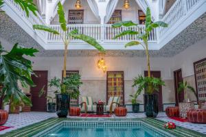 Riad Nuits D'orient Boutique Hotel & SPA في مراكش: مسبح في غرفة فيها اشجار ونباتات