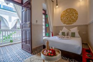a bedroom with a bed and a large window at Riad Nuits D'orient Boutique Hotel & SPA in Marrakesh