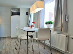 una mesa de comedor con sillas blancas en una habitación en Vakantiehuis Voor Anker, en Egmond aan Zee