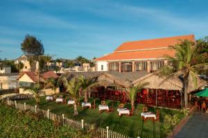 ein Resort mit Tischen und Stühlen vor einem Gebäude in der Unterkunft Sea Lion Beach Resort Mui Ne in Mui Ne