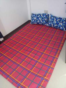 uma cama num quarto com um cobertor vermelho e azul em IRIGA CITY TRANSIENT HOUSE em Iriga City
