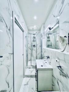 een witte badkamer met een douche en een wastafel bij Lifestyle Veneto Suite in Rome