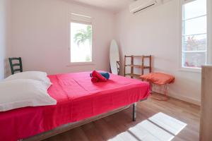 um quarto com uma cama vermelha e um cobertor vermelho em Kay Azzurra em Schœlcher