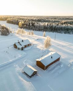 una vista aérea de un campo cubierto de nieve con edificios en Hommala, en Raiskio
