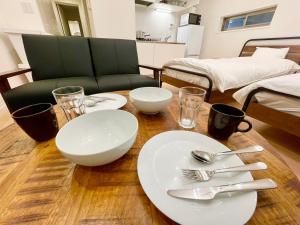 einem Tisch mit weißen Tellern und Besteck in der Unterkunft SALON Shibuya in Tokio
