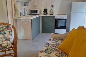 eine Küche mit einem Kühlschrank und einer Arbeitsplatte in der Unterkunft Une pause Champêtre : gîte avec terrasse in Saint-Cierge-sous-le-Cheylard