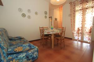 a living room with a dining room table and a chair at Alfa Apartmerts in Lido di Pomposa
