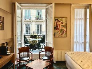 a bedroom with a bed and a large window at Beausejour Ranelagh in Paris