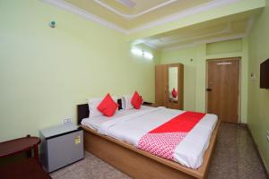 um quarto com uma cama grande e almofadas vermelhas em OYO Kingstar Resort em Pānāgarh