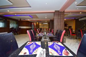 uma sala de jantar com mesas e cadeiras com comida em OYO Kingstar Resort em Pānāgarh