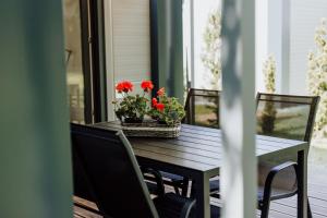 a wooden table with flowers on a porch at Rowerowe domki in Dobrenice +7 photos