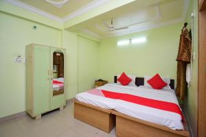 um quarto com uma cama grande e almofadas vermelhas em OYO Kingstar Resort em Pānāgarh