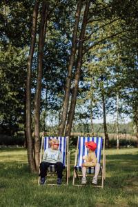 two people sitting in chairs in the grass at Rowerowe domki 