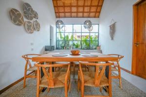 ein Esszimmer mit einem Holztisch und Stühlen in der Unterkunft 4BR Luxury Tropical Jungle Villa 4 Mins to Beach in Tanah Lot