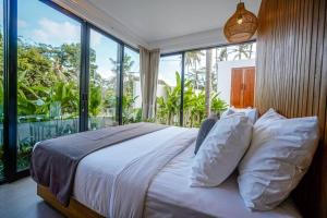 Schlafzimmer mit einem Bett und einem großen Fenster in der Unterkunft 4BR Luxury Tropical Jungle Villa 4 Mins to Beach in Tanah Lot