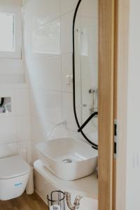 a white bathroom with a sink and a toilet at Rowerowe domki in Dobrenice