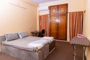 Schlafzimmer mit einem Bett und einer Holztür in der Unterkunft Burhani Manzil in Udaipur