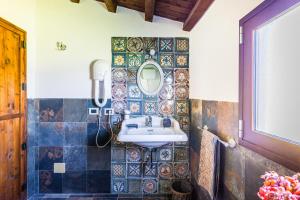 a bathroom with a sink and a mirror on the wall at Authentic Sicilian Charm, pool, sea view, wi-fi & parking in Avola