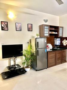 a kitchen with a stainless steel refrigerator and a tv at BohoLush by Evanka in Vagator