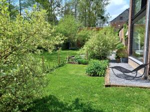 um jardim com um banco na relva em L'Etable de Joseph- calme et rivière em Honnay