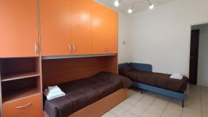 Habitación con armarios marrones y sofá de cuero marrón. en Pitagora, en Pavia