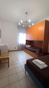Un dormitorio con 2 camas y una mesa en una habitación en Pitagora, en Pavia