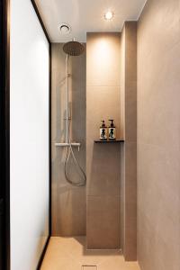 een douche in een badkamer met een glazen deur bij Doryssa Lithos Hotel in Pythagoreio