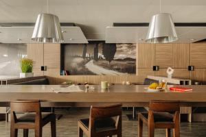 une cuisine avec une grande table et des chaises en bois dans l'établissement Crown Hotel Eindhoven Centre, à Eindhoven