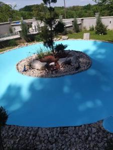 błękitny basen z drzewem w środku w obiekcie Pedjin Kutak Brcko w mieście Vražići
