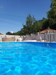 - une piscine d'eau bleue en face d'une maison dans l'établissement Pedjin Kutak Brcko, à Vražići