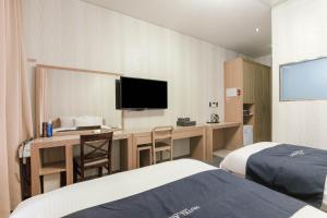 a hotel room with a desk and a television at Incheon Aiport Airrelax hotel in Incheon