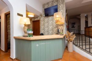 a kitchen with a bar with a tv on a wall at Hotel Tugasa Villa de Algar in Algar
