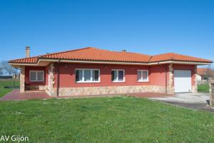 a red house with a green lawn in front of it at AV Casa Aurora - Quintes in Villaviciosa