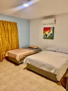 a bedroom with two beds and a painting on the wall at A Famosa resort villa 877 snooker karaoke BBQ 5BR in Kampong Alor Gajah