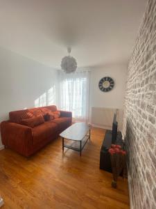 a living room with a couch and a table at Appartement spacieux avec parking in Lempdes