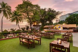 een restaurant met tafels en stoelen op het gras bij Taj Cidade de Goa Heritage, Goa in Panaji