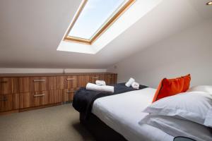 - une chambre mansardée avec un lit et une lucarne dans l'établissement Dunston Stables- Spectacular Countryside Setting, à Newton Abbot