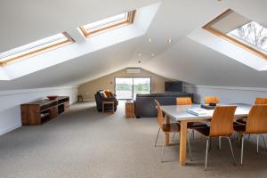an attic living room with skylights and a table and chairs at Dunston Stables- Spectacular Countryside Setting in Newton Abbot