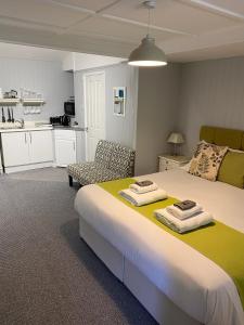 um quarto com uma cama grande e toalhas em Petherton Cottage Studios em Ringwood