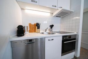 a kitchen with a sink and a dishwasher at Apartments - Kitchen & More in Düsseldorf
