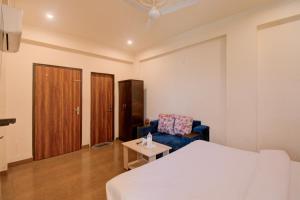 a bedroom with a bed and a chair and a table at Hotel Bhagwati Palace in Jaipur