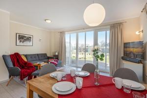 a living room with a table and chairs and a couch at Ferienhaus Sonne 6c in Korswandt